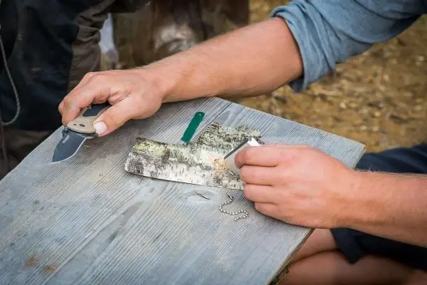 Messer schneidet Rinde auf einem Holztisch