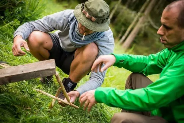 Person baut eine Konstruktion aus Holzstöcken
