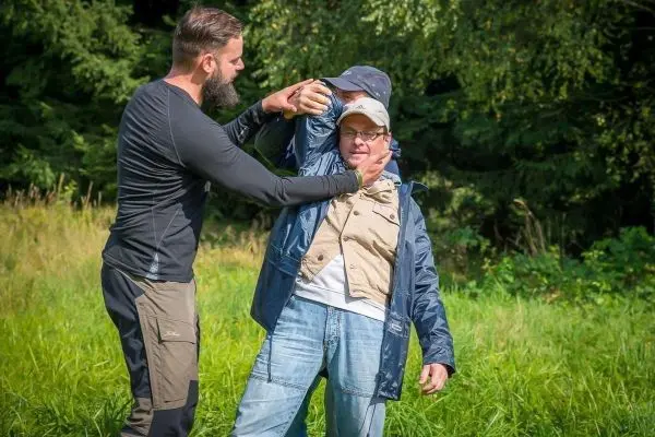 Person demonstriert eine Technik zur Selbstverteidigung im Freien