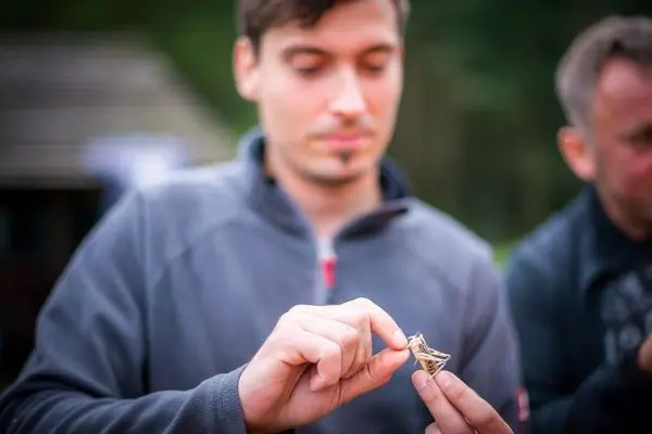 Person hält ein kleines Objekt in der Hand