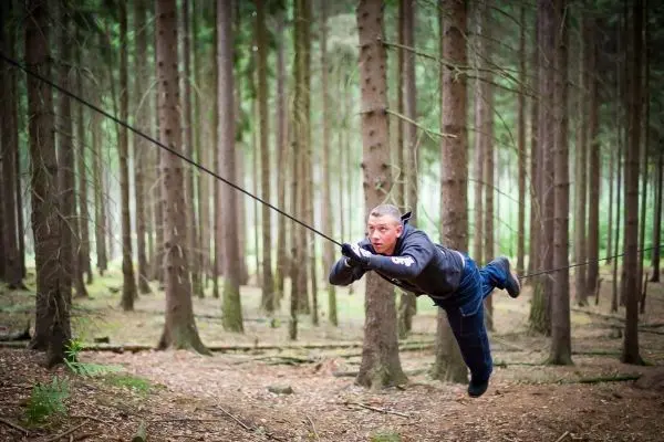 Selbstgebaute Seilquerung wird von einer Person überquert