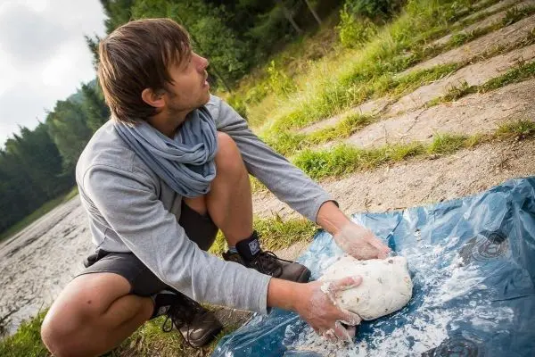 Teig wird auf einer blauen Plane geknetet