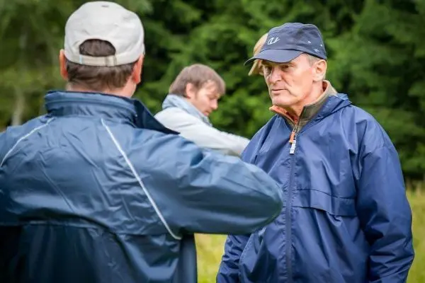 Zwei Personen in Regenjacken unterhalten sich im Freien
