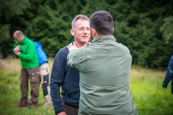 Zwei Personen stehen sich gegenüber und führen eine Übung zur körperlichen Interaktion durch