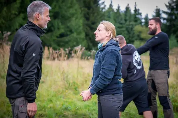 Zwei Personen stehen sich gegenüber und sprechen, während zwei weitere im Hintergrund stehen