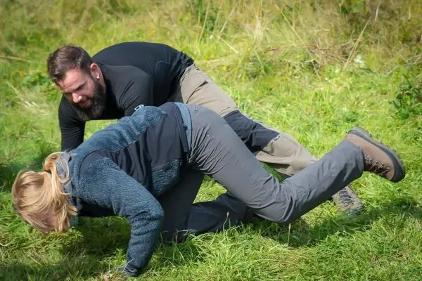 Zwei Personen üben eine Bodentechnik im Gras