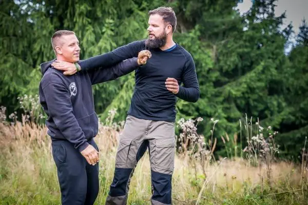 Zwei Personen üben eine Selbstverteidigungstechnik im Freien