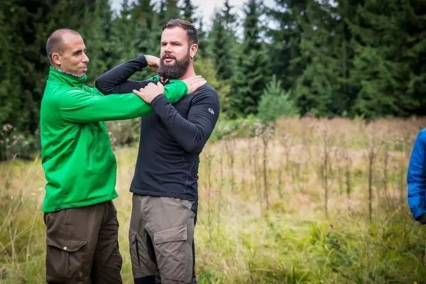 Zwei Personen üben eine Technik zur Selbstverteidigung im Freien