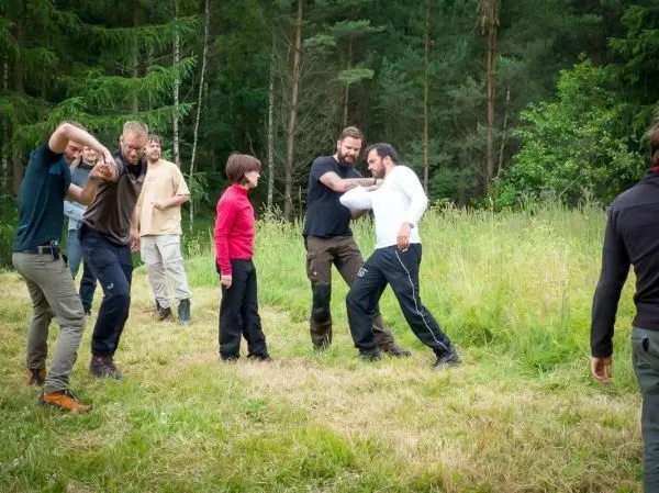 Gruppe übt körperliche Techniken im Freien während eines Kurses