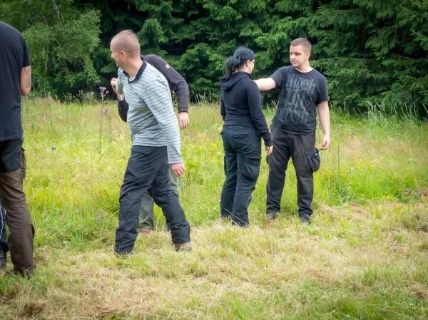 Gruppe von Personen übt in einer Wiese miteinander