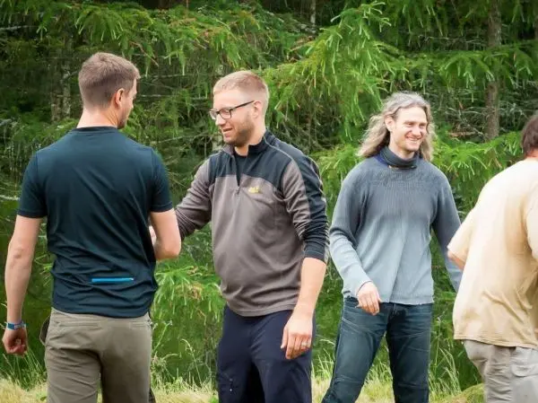 Gruppenaustausch mit Handschlag zwischen mehreren Personen im Freien