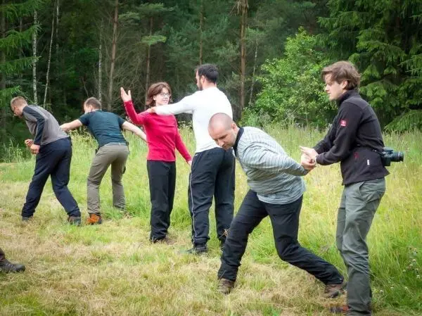 Gruppendynamik beim Üben von Teamarbeit im Freien, Personen halten sich an den Händen