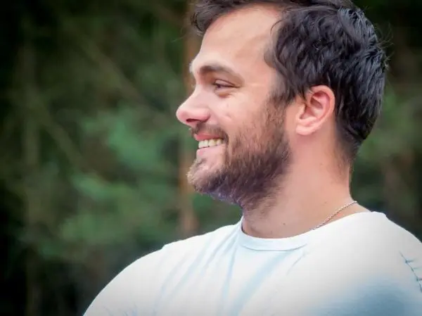 Lächelnder Mann mit Bart in einem Waldgebiet