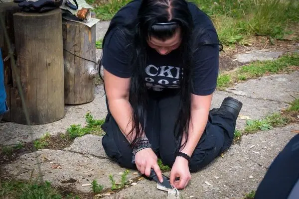 Messer schneidet Holzstück auf dem Boden