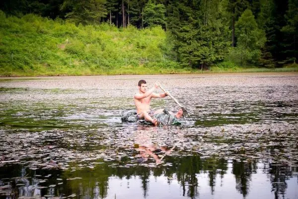 Person paddelt auf einem Wassergefährt im See