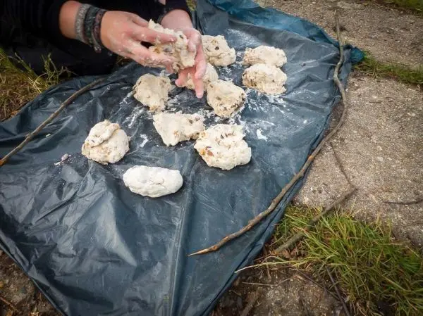 Teigstücke werden auf einer Tarp-Notunterkunft geformt und bearbeitet