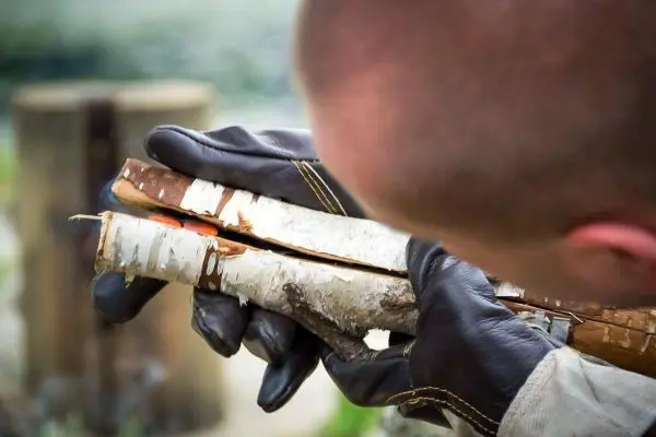 Zwei Holzstücke werden mit einem Messer bearbeitet