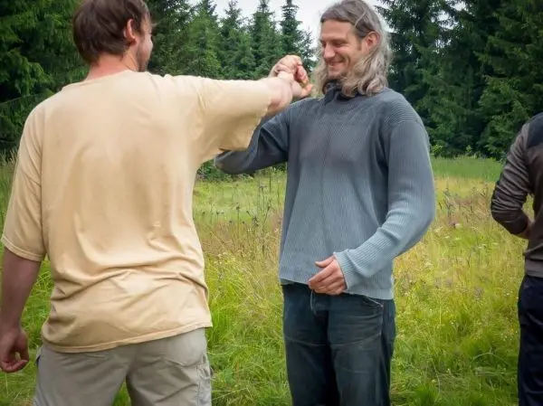 Zwei Personen führen eine Handgelenk-Übung im Freien durch