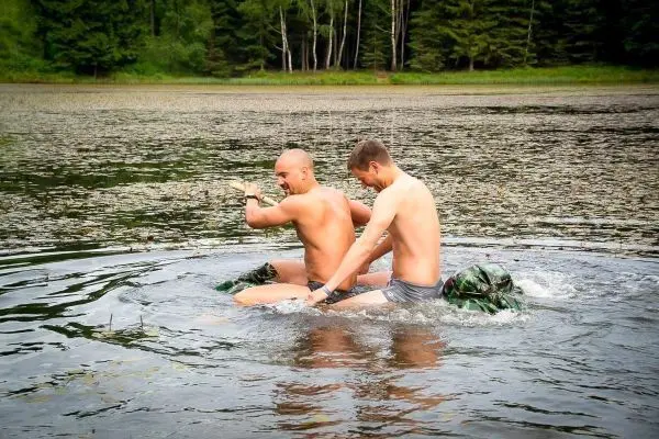Zwei Personen paddeln auf einem improvisierten Floß im Wasser
