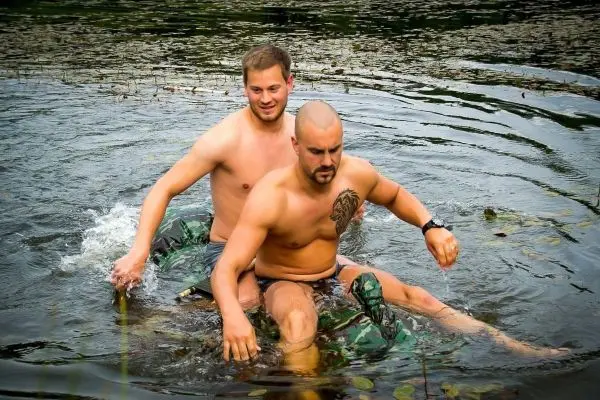Zwei Personen sitzen auf einem schwimmenden Objekt im Wasser und paddeln