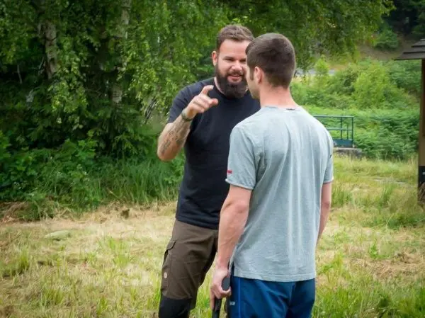 Zwei Personen stehen sich gegenüber und diskutieren intensiv im Freien