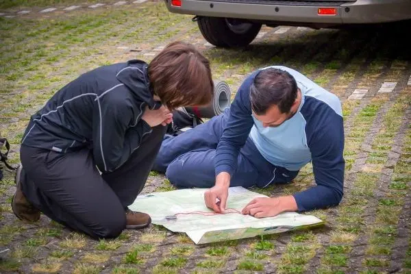 Zwei Personen studieren eine Karte auf dem Boden