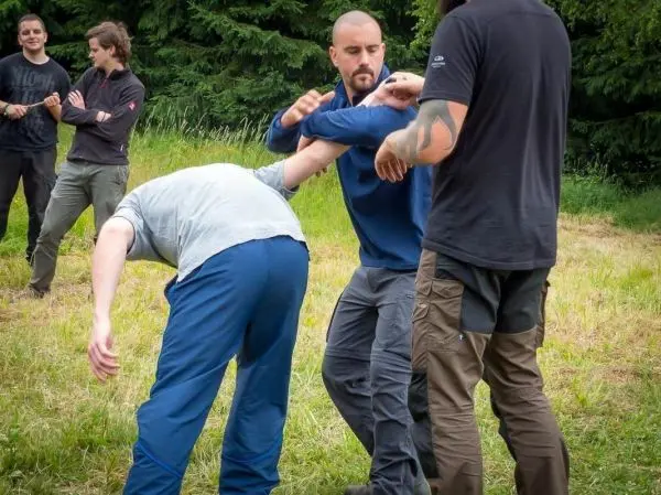 Zwei Personen üben eine Selbstverteidigungstechnik im Freien