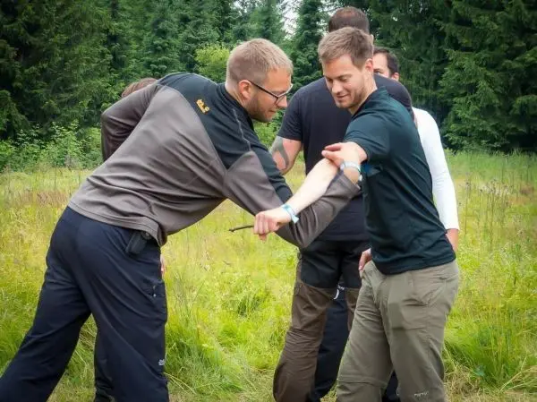 Zwei Personen üben eine Selbstverteidigungstechnik im Freien