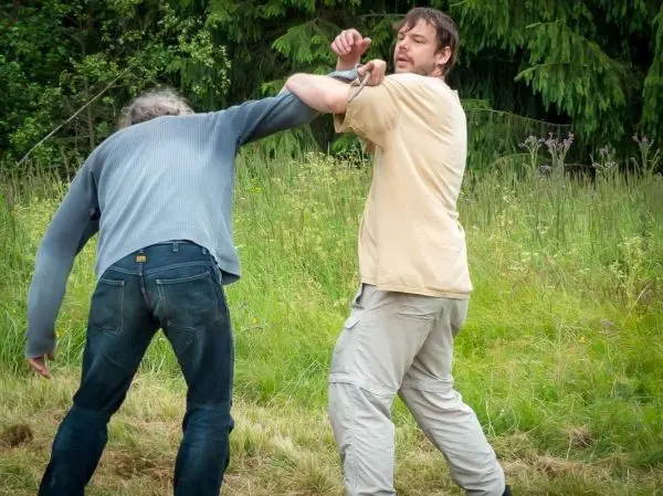 Zwei Personen üben eine Selbstverteidigungstechnik im Freien aus