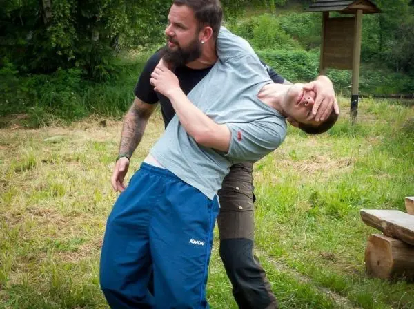 Zwei Personen üben eine Selbstverteidigungstechnik im Freien aus