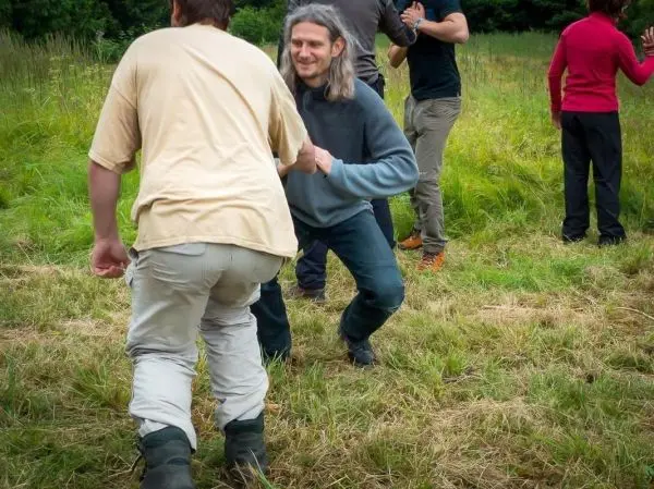 Zwei Personen üben eine Technik im Stehen auf einer Wiese