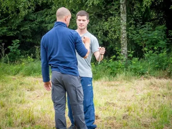 Zwei Personen üben eine Technik zur Befreiung aus einer Umklammerung