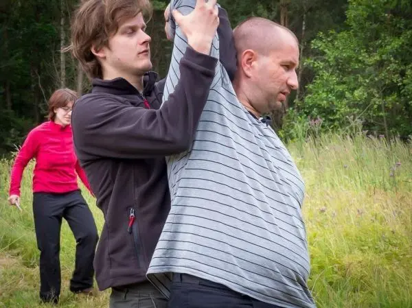 Zwei Personen üben eine Technik zur Kontrolle eines Gegners im Freien