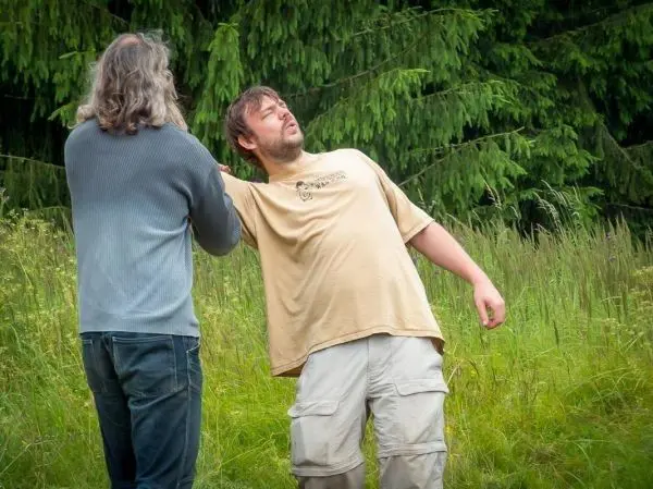 Zwei Personen üben eine Technik zur Unterstützung in einer stehenden Position aus