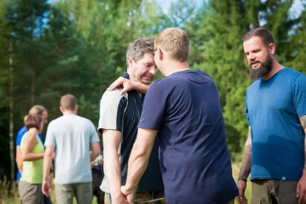 Gruppendynamik in einem Waldgebiet, zwei Personen stehen eng beieinander