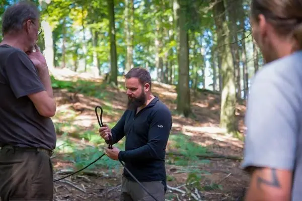 Mann demonstriert Knotentechnik mit Seil im Wald
