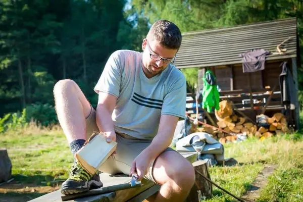 Messer bearbeitet Holzstück auf einer Werkbank im Freien