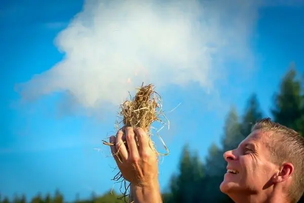 Zunder glimmt und erzeugt Rauch in der Hand