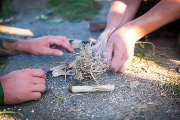 Zunder wird zwischen zwei Holzstücken bearbeitet