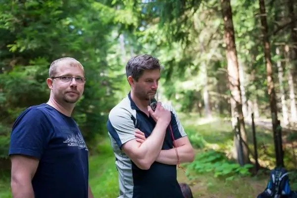 Zwei Personen stehen im Wald und beobachten die Umgebung