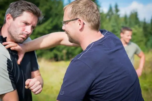 Zwei Personen üben eine Selbstverteidigungstechnik im Freien
