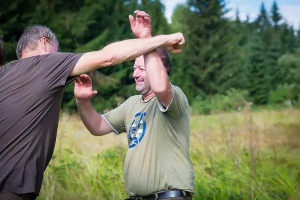 Zwei Personen üben eine Selbstverteidigungstechnik im Freien aus