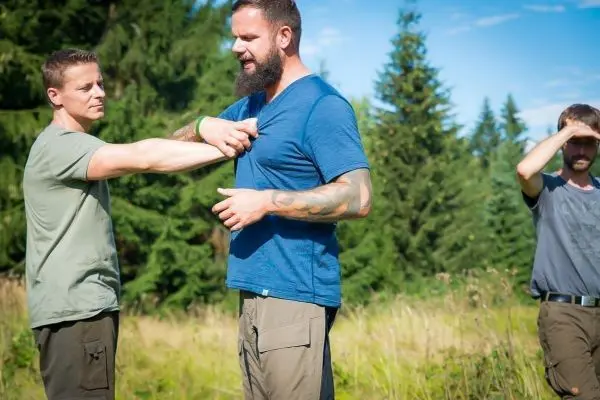 Zwei Personen üben eine Technik zur ersten Hilfe im Freien
