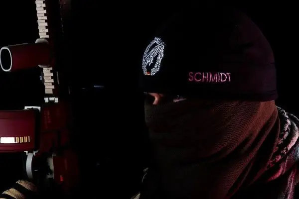 Mann mit vermummtem Gesicht hält Gewehr in der Hand