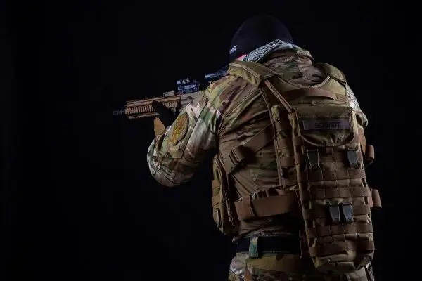Soldat in Tarnkleidung zielt mit einem Gewehr auf ein Ziel