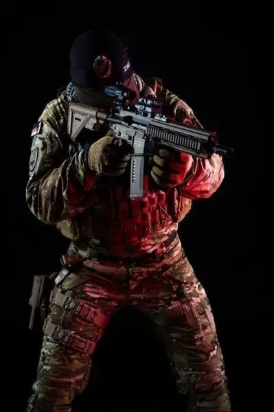 Soldat in Tarnuniform hält ein Gewehr in Schussposition