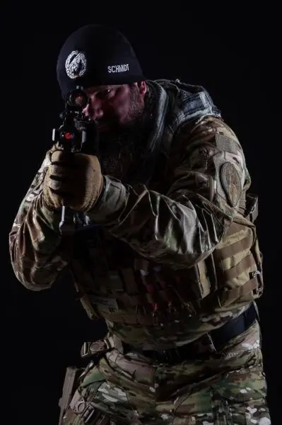 Soldat in Tarnuniform zielt mit einer Waffe auf ein Ziel