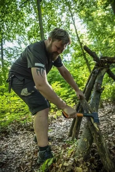 Axt spaltet Holz für eine improvisierte Konstruktion im Wald