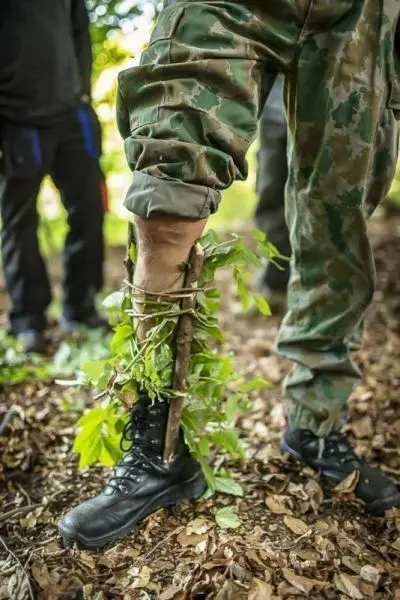 Ein improvisierter Schienenverband aus Ästen und Blättern stabilisiert das Bein
