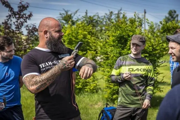 Ein Teilnehmer demonstriert ein Messgerät im Freien, während andere zuschauen